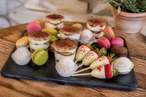 Plateau de desserts pour apéro dînatoire : verrines tiramisu, macarons et rochers coco sur ardoise